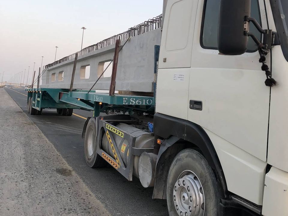 East Star truck hauling a precast concrete beam on a flatbed trailer